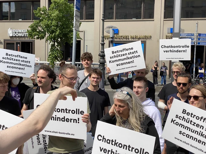 Demoteilnehmer.innen mit Protestschildern. Im Hintergrund ist die Europäische Vertretung zu erkennen. 