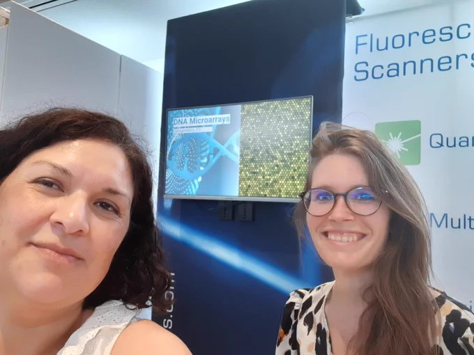 Two girls in front of the stand of Innopsys at the BioChip Berlin exhibition