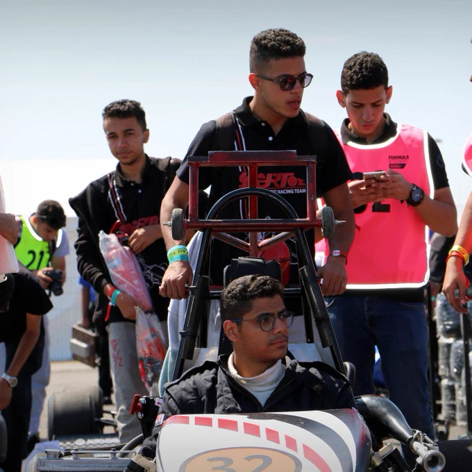 The team from Cairo and their car stops for a moment in the Silverstone paddock while the team member pushing behind chats with another colleague