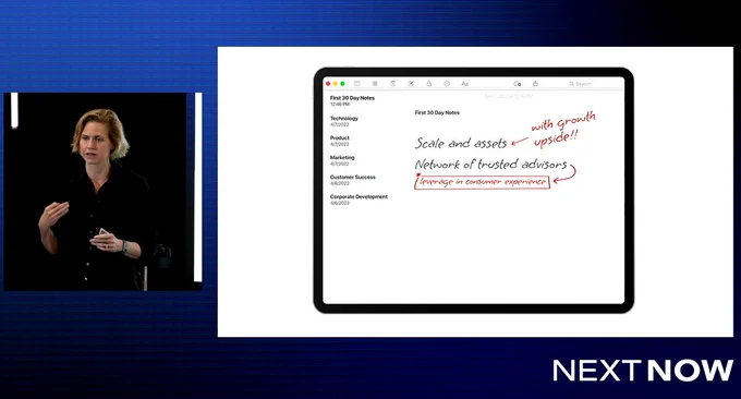 Melissa McSherry is speaking on stage with her presentation slides behind her on the screen. 