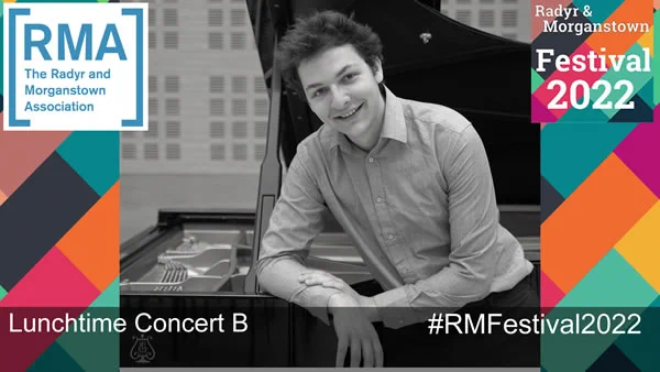 Dominic leans on an open grand piano showing his very long fingers as an advert for Lunchtime Concert B in the Radyr & Morganstown Festival 2022