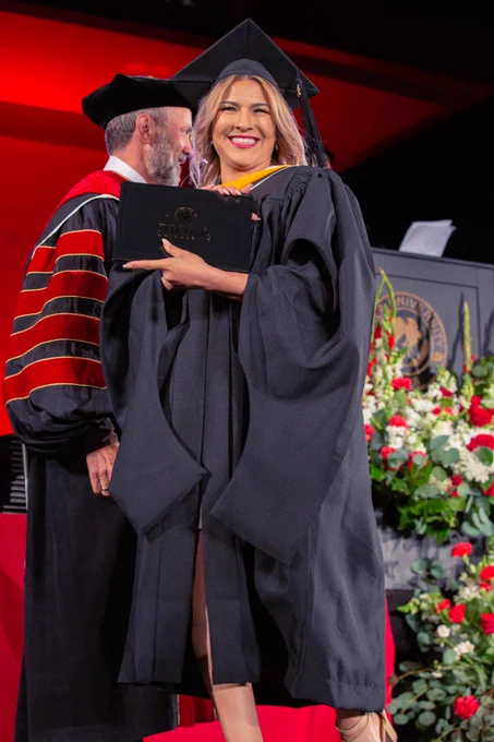 Graduate receiving her diploma on stage.