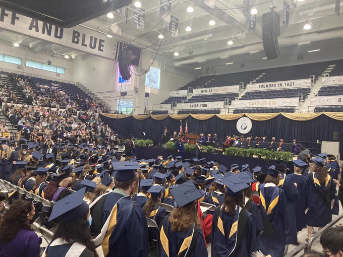 Photo of a sea of graduating students in line to receive their awards, wearing blue caps and gowns.