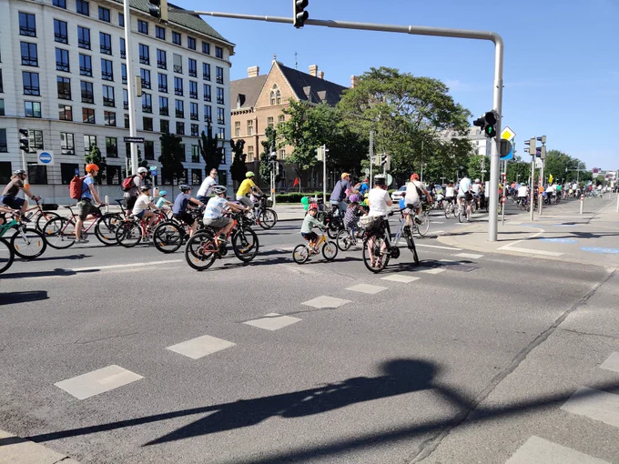 sehr viele Fahrräder mit Kindern und Erwachsenen auf einer Straße