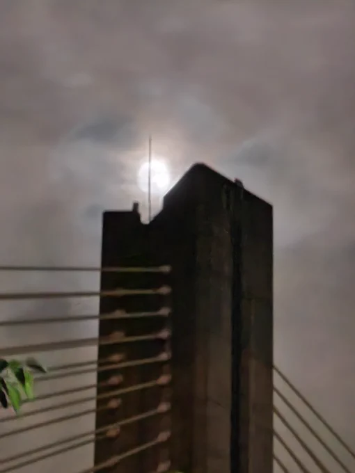 A close up, and high exposure photo, of the top of a bridge tower silhouetted against the moon at night, composed to look like the Eye of Sauron as was visually depicted in the movie adaptation.