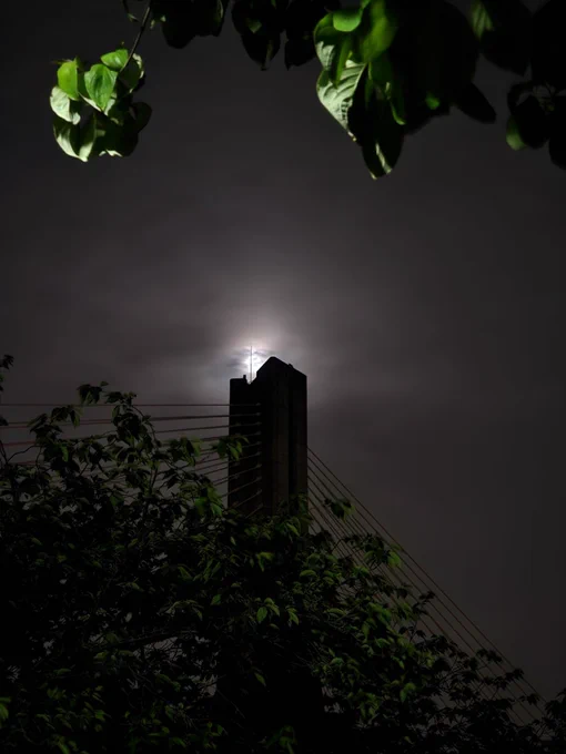 A bridge tower silhouetted against the moon at night, composed to look like the Eye of Sauron as was visually depicted in the movie adaptation.