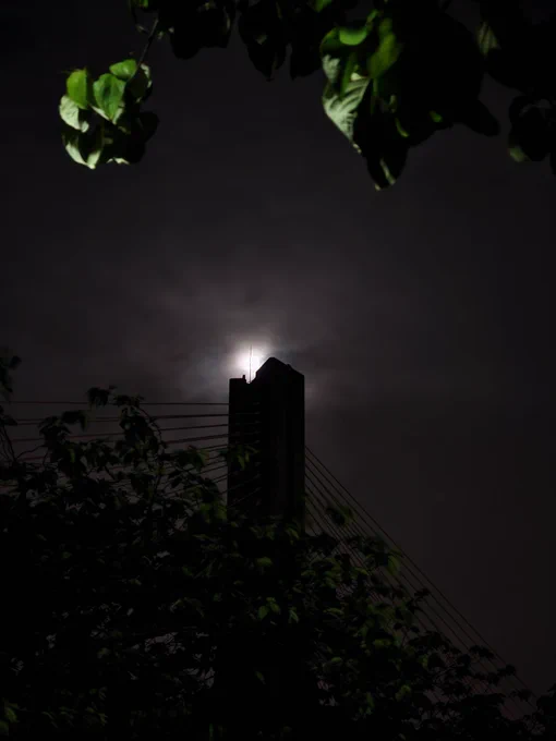 A bridge tower silhouetted against the moon at night, composed to look like the Eye of Sauron as was visually depicted in the movie adaptation.