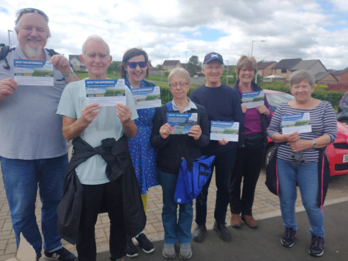 Seven Yes activists holding leaflets and smiling. 