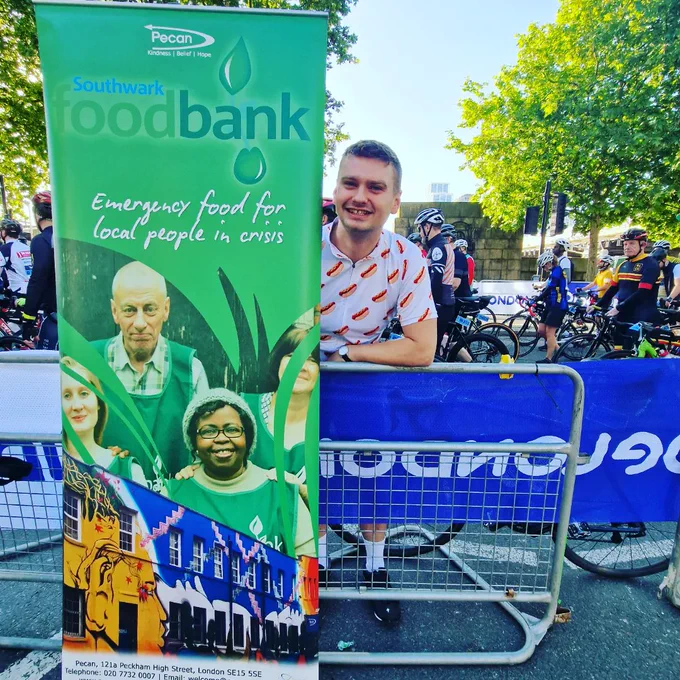 Cyclist next to foodbank banner