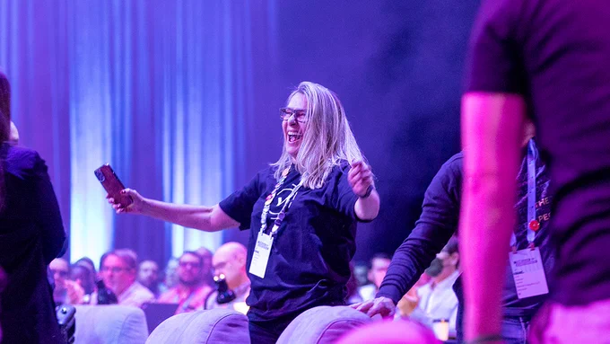 Smiling Tableau Conference attendee with arms up