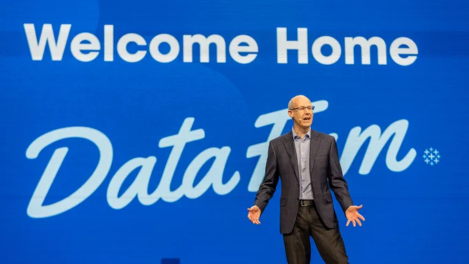 Tableau CEO on stage during Tableau Conference keynote in front of sign that says "Welcome Home DataFam."