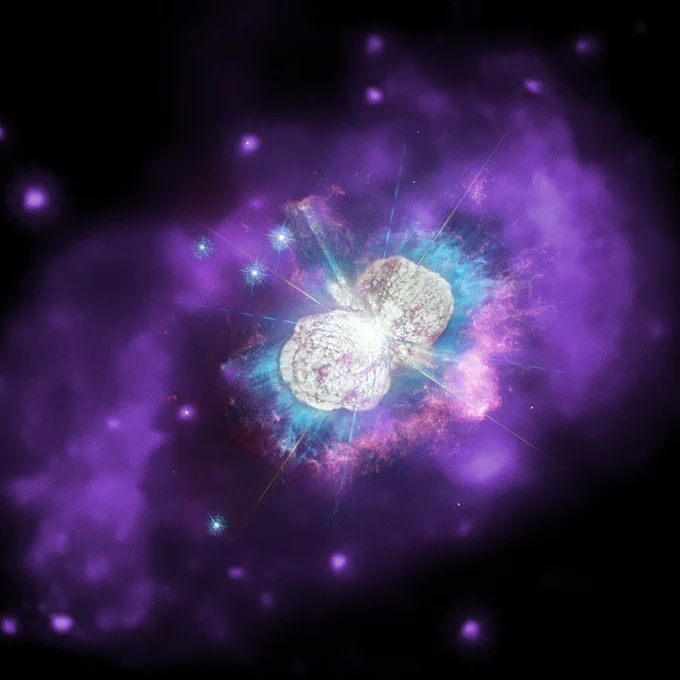 Illustration of the Eta Carinae star system, with a bright white bulbous nebular in the center, surrounded by blue and purple glowing gasses and stars