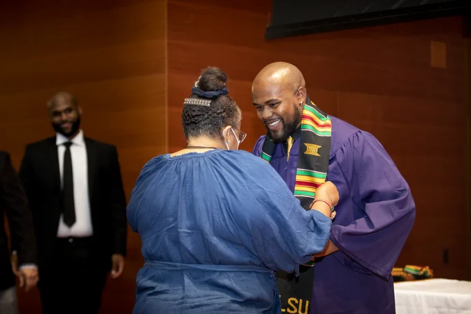 A graduate receives a Kente Cloth at the African American Robing Ceremony.