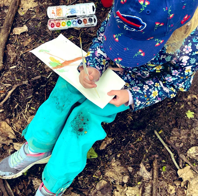 First grader using feather to paint