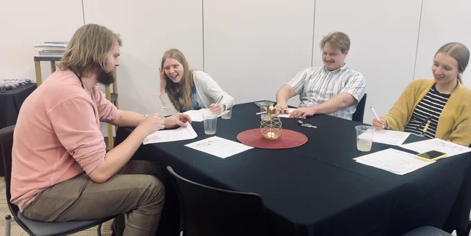 Several people seated at a table, talking.
