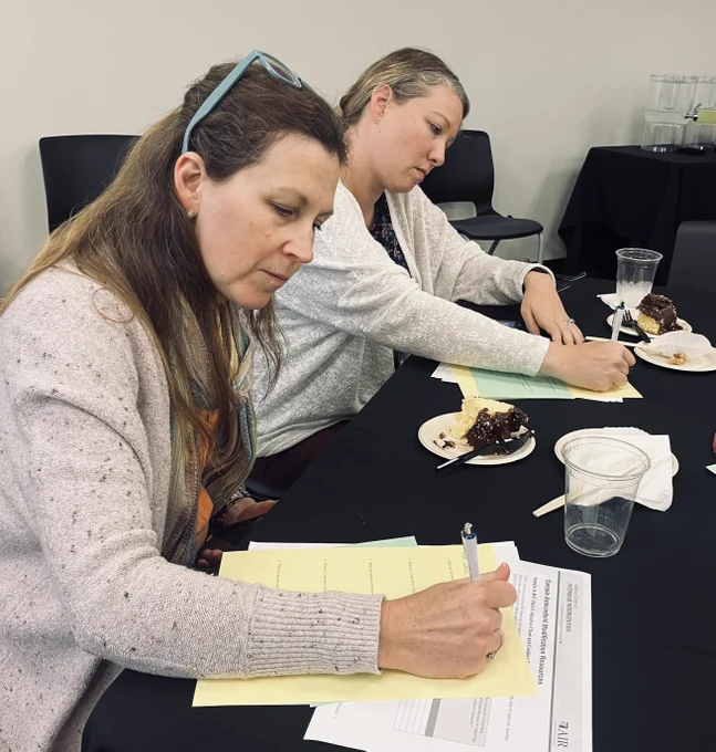 Two women writing at a table.