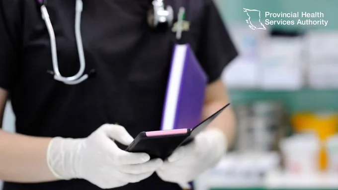 Nurse checking a phone in a medical setting.