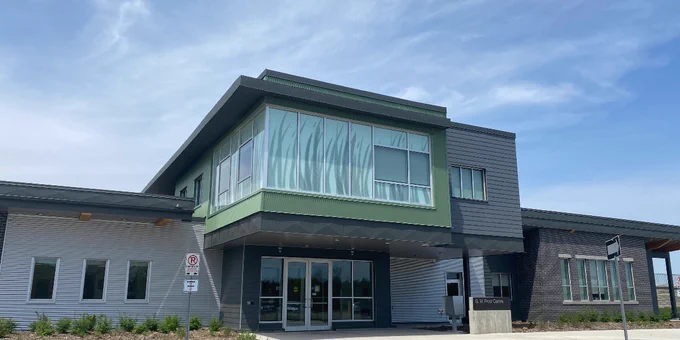 A photo of the GM Frost Centre building. The building is grey and green, with a Turfgrass motif printed on the second floor.
