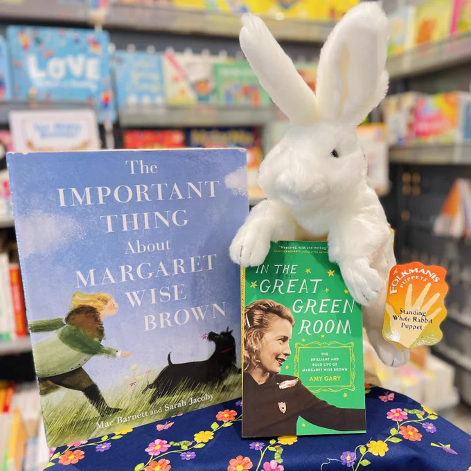Two books written about Margaret Wise Brown are posed with a white rabbit puppet inside the Carle Bookshop  