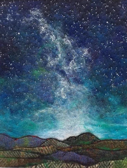Pictorial textile artwork featuring a layered hilly landscape created in different materials giving the impression of distance and texture with a graduating darkening blue star filled night sky above