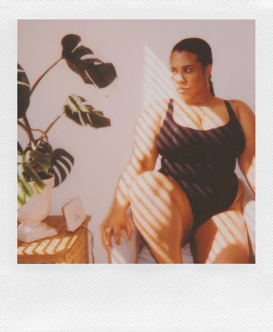 London plus size model, singer and influencer Lovelle Hill polaroid picture modelling the new in black body from Lizzo's brand YITTY. On set for London curve model agency BRIDGE