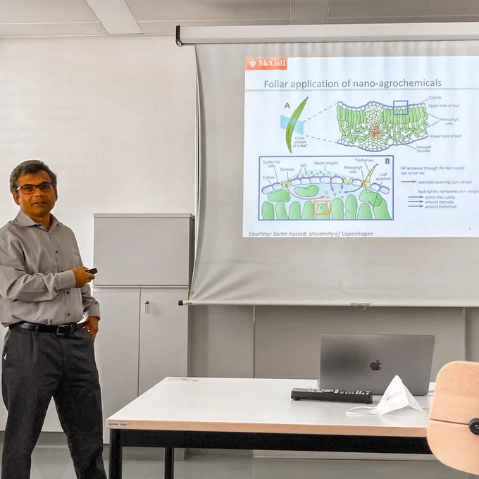 Subhasis Ghoshal in front of a power point slide with a leave structure