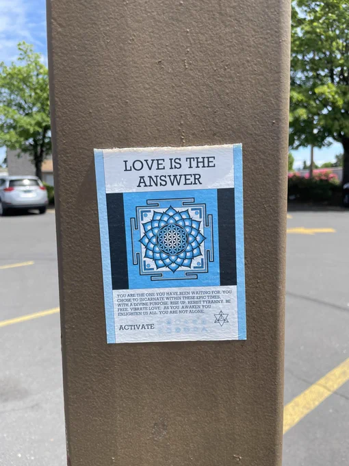 Love is the Answer decal on a light post in a parking lot on Q Street in Springfield