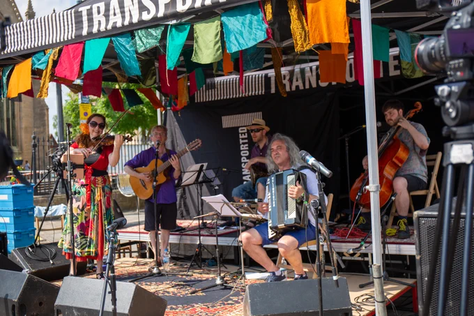 5 musicians play their instruments underneath a Transported gazebo in Boston on a sunny day