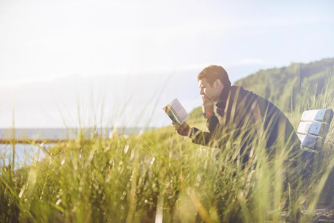 Image of man reading on a bench next to a lake/wilderness area by Pexels from Pixabay. 