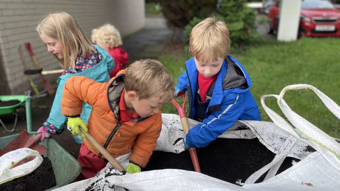Squirrels scouts filling wheelbarrows with soil