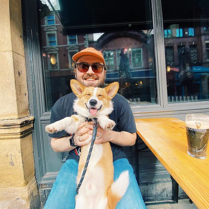 An oporto customer holds up his happy corgi outside on call lane 🐶❤️