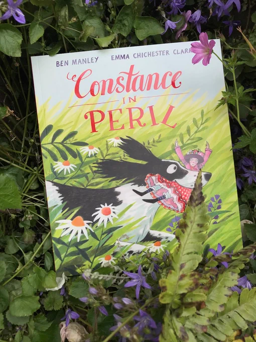 A copy of Constance in Peril surrounded by flowers.