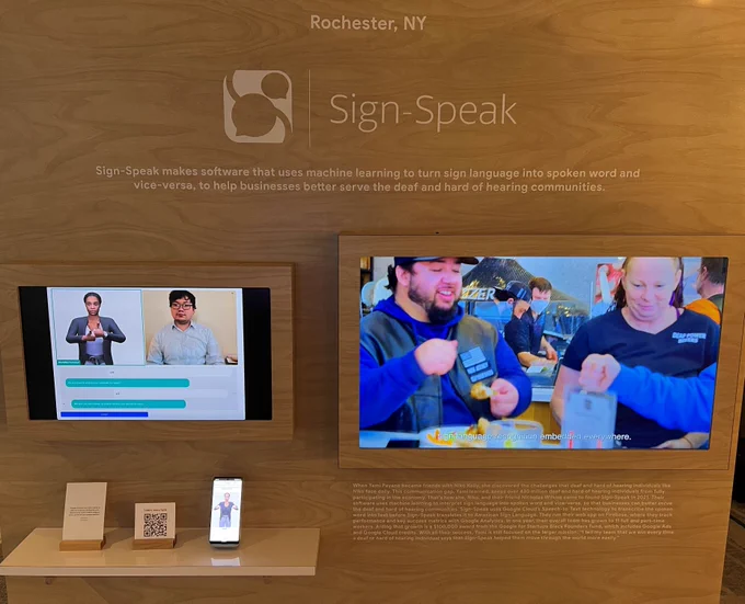 Brown presentation board with Sign-Speak branding and demos. 
