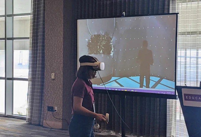 Presenter in VR headset demonstrates VR environment 