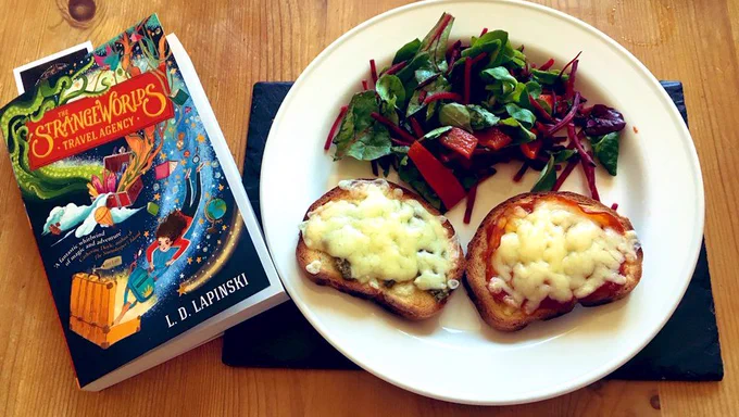 A copy of "The Strange Worlds Travel Agency" by L.D. Lapinski and a plate of cheese on toast