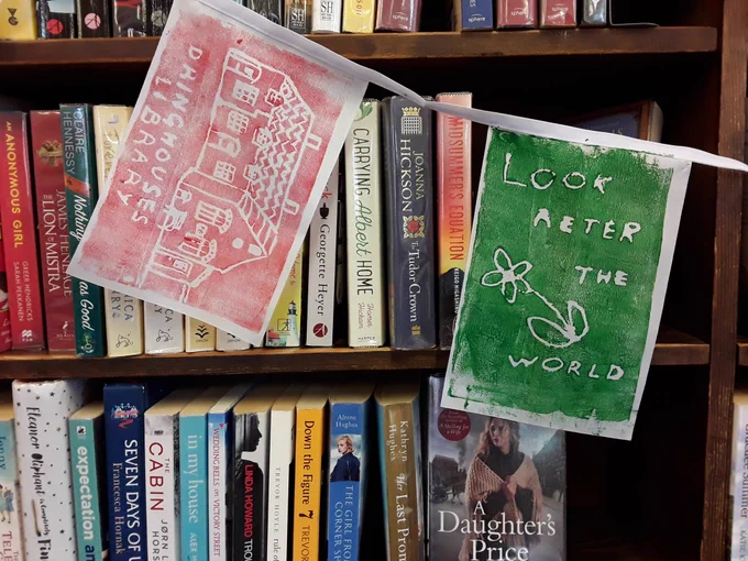 2 more flags in front of bookcases, Look after the World, and a picture of Dringhouses library