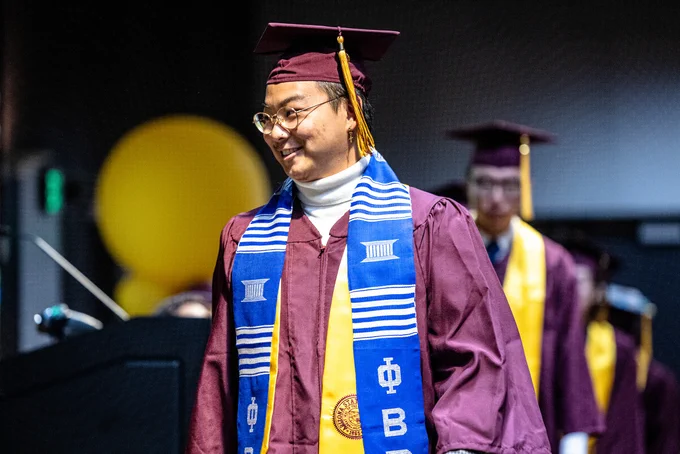 Student walks across stage to receive his stole.