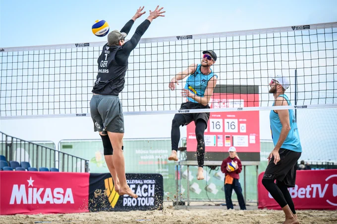 Chaim Schalk hits off the block during a beach volleyball match