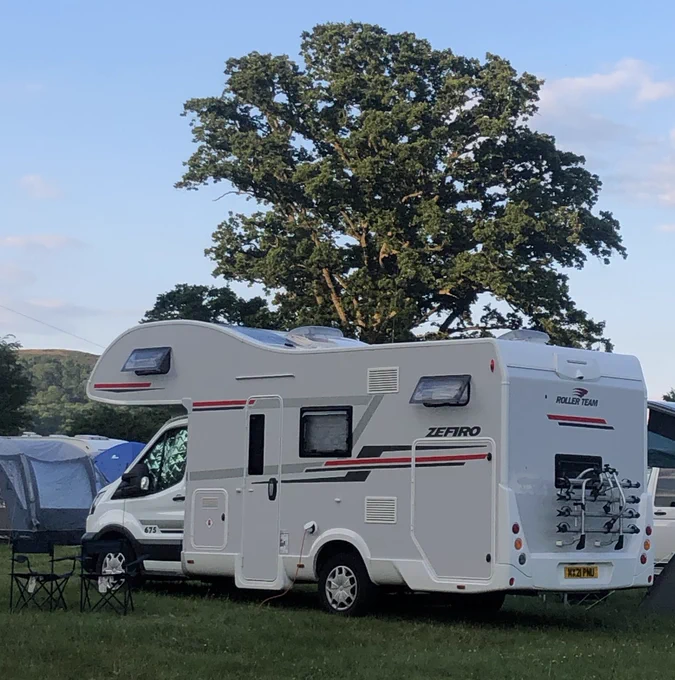 A Ford Zefiro 675 Motorhome in a field surrounded by other tents and motorhomes.