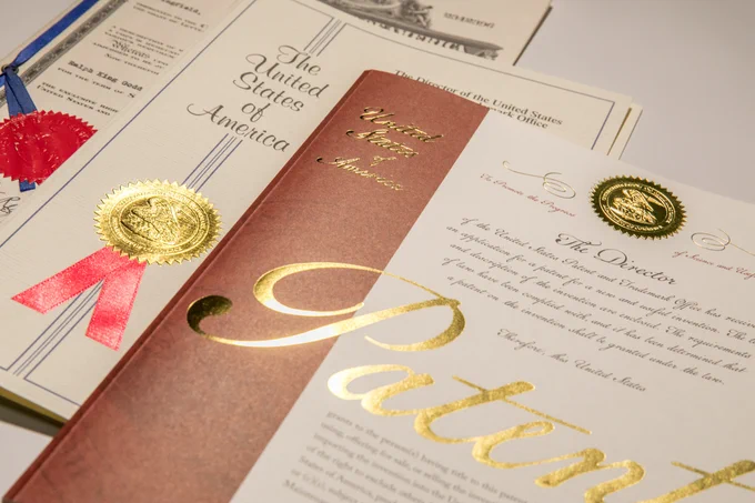 Patent covers showing a ribbon and the word "patent" in gold leaf