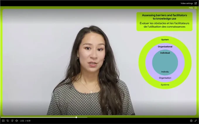 Capture d’une vidéo qui présente la doctorante @JackelineRobergeDao debout au centre de l’image et à droite un visuel ajouté indique en français et en anglais le titre suivant : évaluer les obstacles et les facilitateurs à l’utilisation des connaissances. Et dessous un schéma avec trois cercles concentriques de couleur différentes indiquant du centre vers l’extérieur : individu, organisation, système.