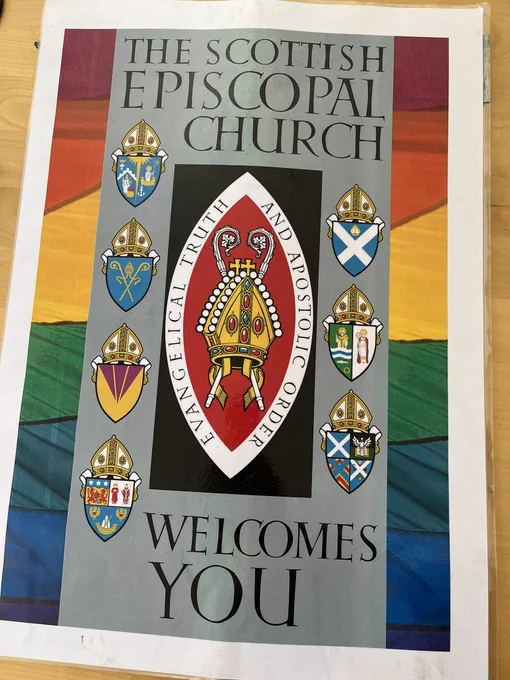 A placard reads The Scottish Episcopal Church Welcomes You on a background of a Pride rainbow.