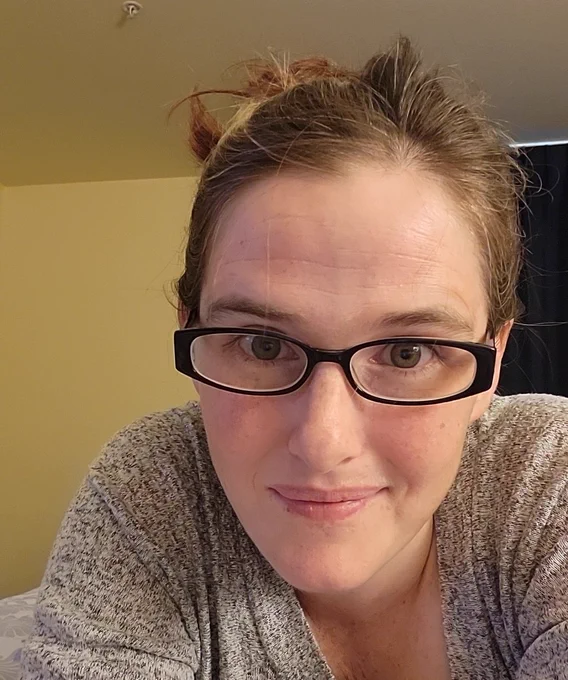 Author with a messy bun and glasses
