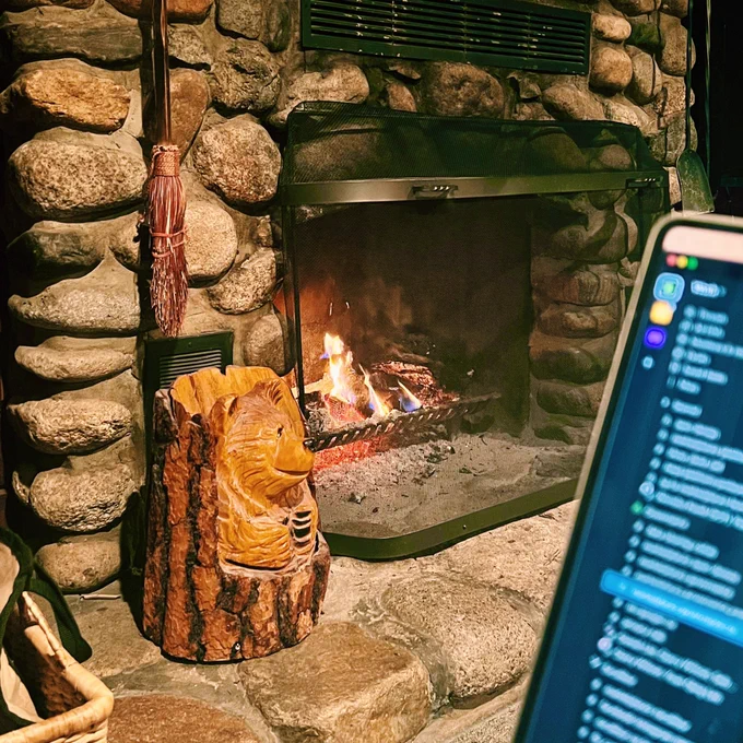 A laptop in front of a fireplace