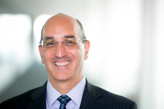 Headshot of Drew Hirshfeld smiling and wearing a suit