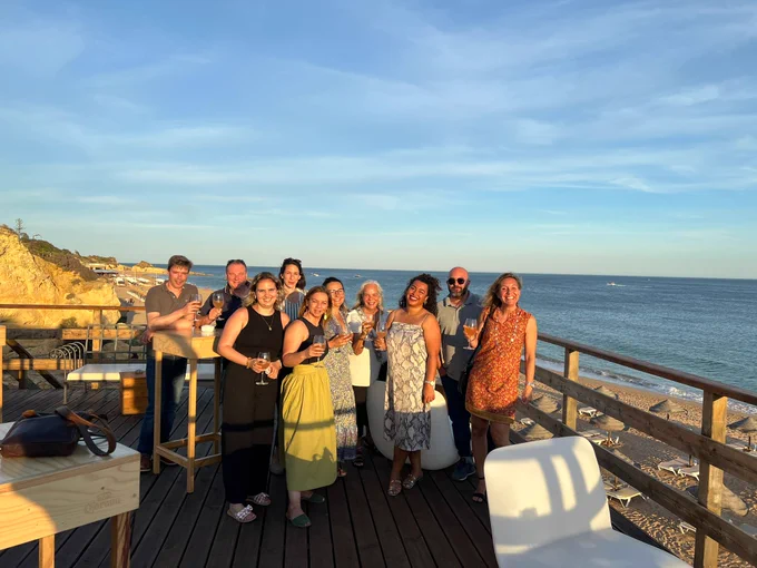 A picture of the social dinner with participants standing and the ocean in the background.
