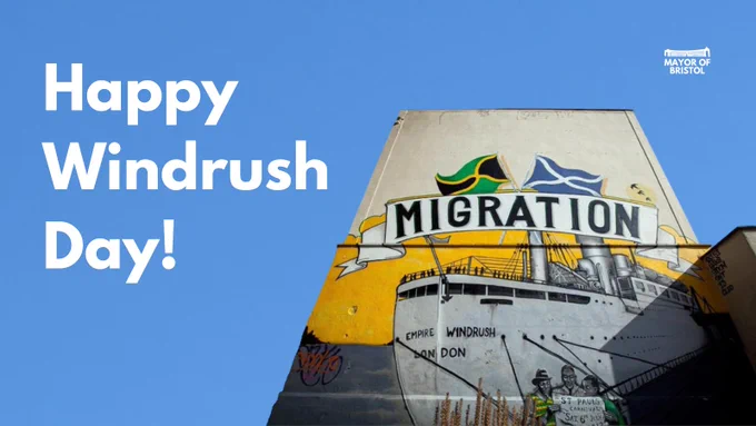 Bristol’s Windrush ‘Migration’ mural stands, against a blue background. White text under the Mayor of Bristol’s logo reads: Happy Windrush Day!