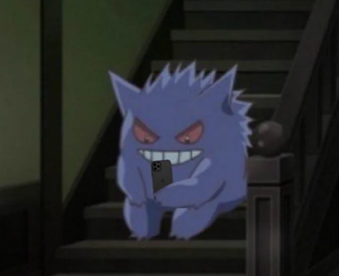 screenshot from the pokemon anime of gengar sitting on some stairs looking mildly devious, edited to be looking down at an iphone