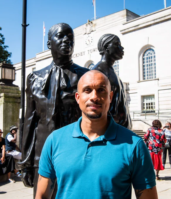 Artist Thomas J Price standing in front of his artwork Warm Shores, commissioned in honour of the Windrush generations. 