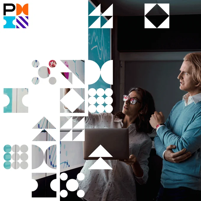 a businessman and businesswoman discussing a projection on the wall in a darkened room